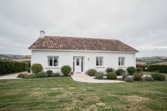 Maison individuelle neuve en Loire-Atlantique avec jardin aménagé et ciel atlantique typique