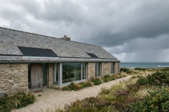 Façade d'une maison passive contemporaine en Bretagne avec murs isolés épais, fenêtres triple vitrage et toiture en ardoise