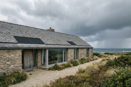 Façade d'une maison passive contemporaine en Bretagne avec murs isolés épais, fenêtres triple vitrage et toiture en ardoise